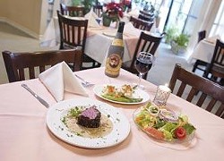 The chef's own ""sensation"" beef tenderloin - pan seared with peppercorns and served with an onion, cream, and cognac sauce, accompanied by sautéed cauliflower and asparagus. It is shown here with a house salad, and a bottle of Faustino Primero.