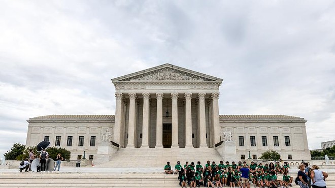 Children listen to a tour guide on the steps of the U.S. Supreme Court in Washington, D.C.