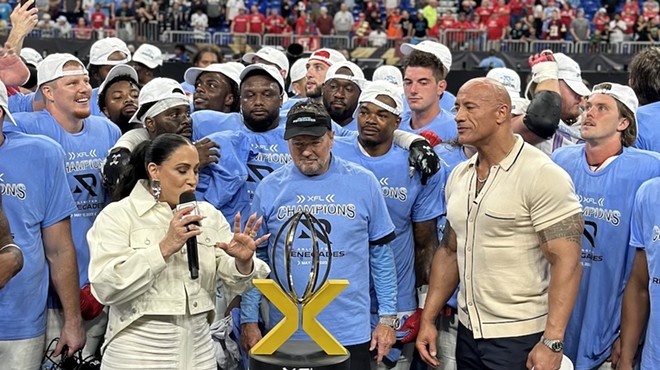 XFL League owners Dany Garcia (left) and Dwayne 'The Rock' Johnson (right) award the championship trophy to the Arlington Renegades at the Alamodome on May 13.