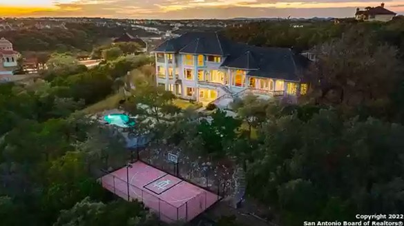 This San Antonio home for sale comes with a swimming pool and sports court built into the hillside