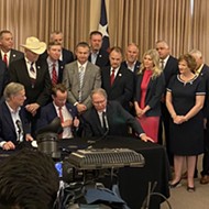 Gov. Greg Abbott signs open-carry bill in San Antonio and the pro-gun crowd shouts down a reporter