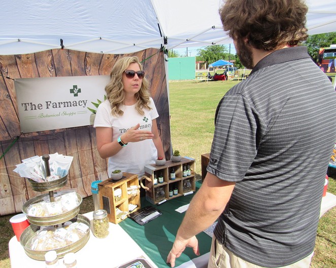 Carolyn Leeper of the Farmacy Botanical Shop discusses her product line at an outdoor mar- ket on the South Side. - Sanford Nowlin