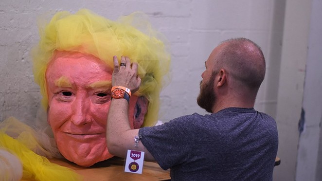 Chris Sauter touches up a papier-mâché version of President Donald Trump back stage Tuesday night at the Empire Theatre. - Jack Myer