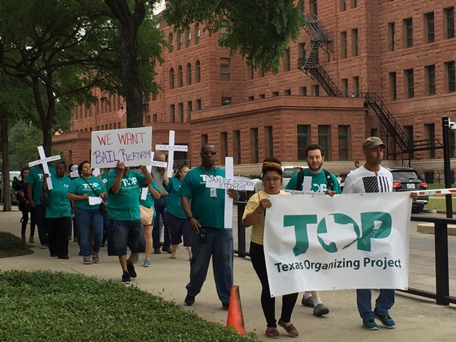 Texas Organizing Project members march in front of the Bexar County Courthouse. - TIFFANY HOGUE