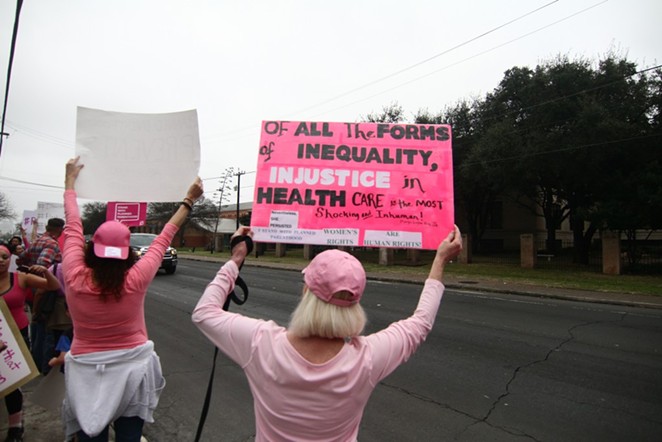 Protesters hold signs at a pro-Planned Parenthood rally in San Antonio. - MICHAEL BARAJAS