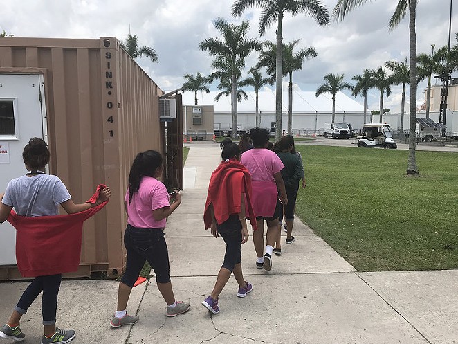 Unaccompanied minors walk inside a facility supervised by the Office of Refugee Resettlement in Homestead, Florida. - Department of Health and Human Services