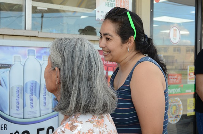 District 3 resident Selena Salazar visits with other residents outside the Gas N' Go store on Wednesday, Sept. 25, 2019. - LEA THOMPSON