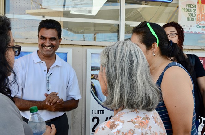 Gas N' Go Owner Shaukat Momin visits with residents outside his store on Wednesday, Sept. 25, 2019. - Lea Thompson