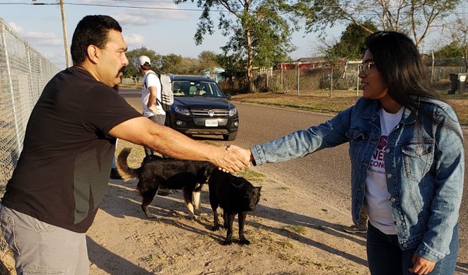 Jessica Cisneros (right) shakes the hand of a potential voter near Mission, Texas. - TWITTER / @JCISNEROSTX