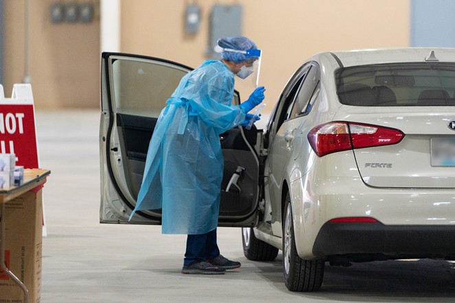 A worker at a drive-through testing facility in San Antonio prepares to collect a sample from someone in a vehicle. - COURTESY PHOTO / CITY OF SAN ANTONIO