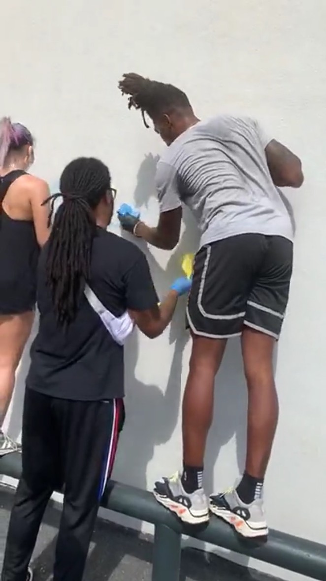 Walker helps scrub graffiti off of a wall in downtown San Antonio - Instagram / buddah