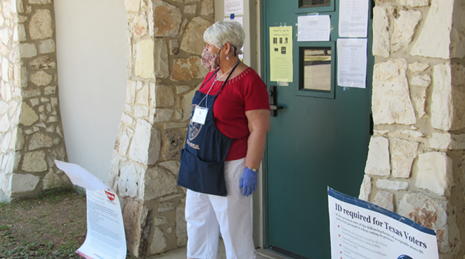 A poll worker stands outside the voting site at San Antonio's Lion's Field. - SANFORD NOWLIN
