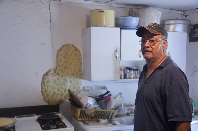 Robert Crain stands in the kitchen of the dilapidated home he shares with his mother, Margaret. - MICHAEL MARKS