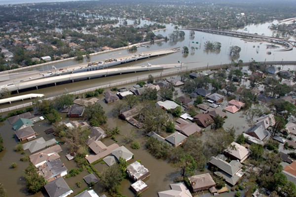 New Orleans, La., August 29, 2005 — Aerial of a flooded New Orleans neighborhood with a roadway going down into flood waters. New Orleans was being evacuated as a result of floods from Hurricane Katrina. Thousand of people were rescued from the flood waters after moving to their roofs and attics. - PHOTO BY JOCELYN AUGUSTINO/FEMA
