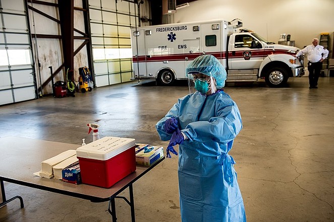 A medic pulls on gloves as she gets ready to work at a mobile testing site in the Texas Hill Country. - WIKIMEDIA COMMONS / CHARLES SPIRTOS