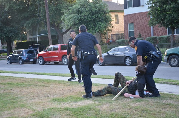 Billingsley on the ground after a man identified as Arturo Trejo tore down his "God Hates Fags" sign - PHOTO BY BRYAN RINDFUSS