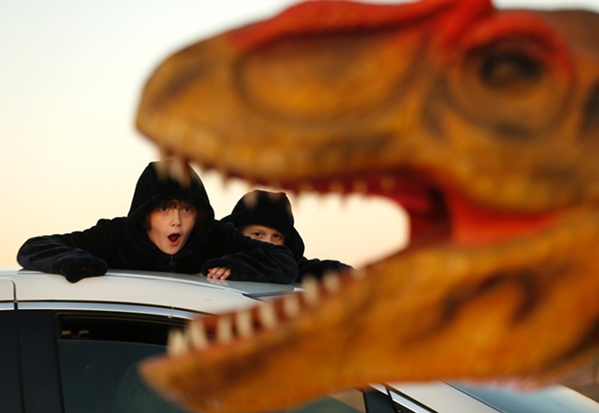 Children look at one of the dinosaurs featured in the Dinosaur Drive-Thru exhibit. - COURTESY / DINOSAUR DRIVE-THRU