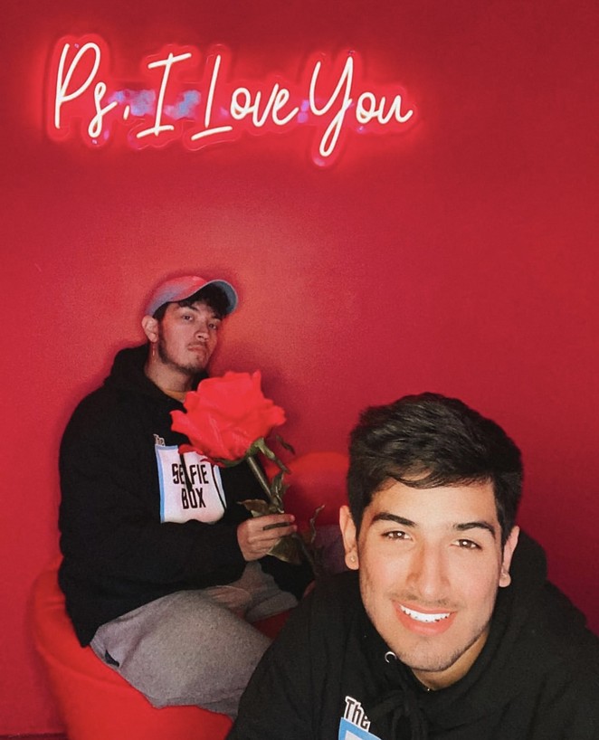 Cesar Ramos (left) and Michael Reyes smile for a photo inside The Selfie Box's red room of love. - COURTESY OF MICHAEL REYES