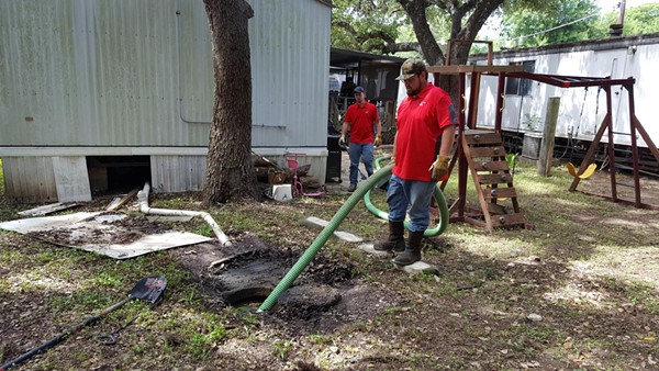 Maintenance staff clean up raw sewage outside an Oak Hollow home. - City of San Antonio / Ray Gurza