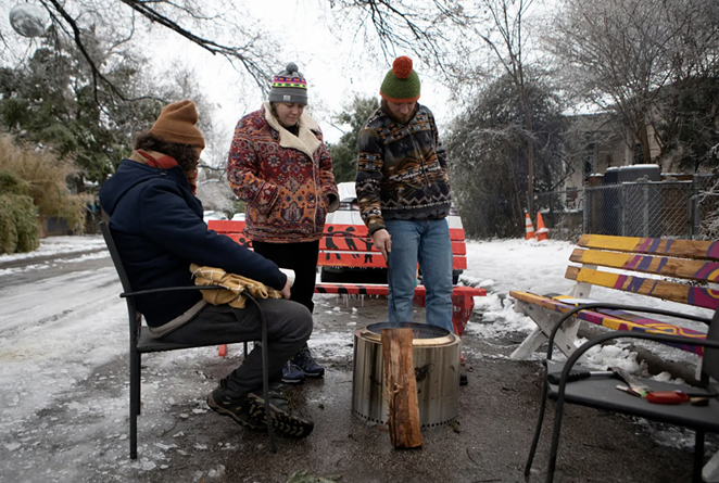 From left: Martin Xoxa, Chelsea Pursley and Joe Williams build a fire on Thursday to keep warm outside of Pursley's home in East Austin. The group had been without power since Monday evening. - MIGUEL GUTIERREZ JR. / THE TEXAS TRIBUNE