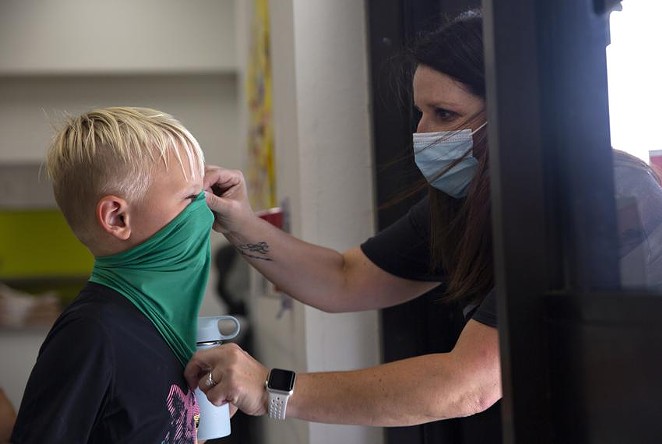 Teachers ensure students have their masks on correctly on the first day of in-person classes at Highland Village Elementary. - SHELBY TAUBER / TEXAS TRIBUNE