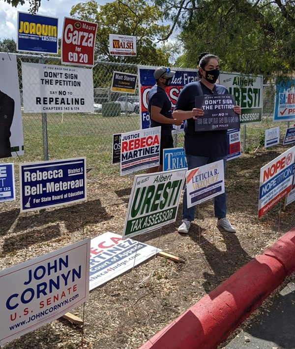 Opponents of Fix SAPD's petition drive hold up signs at a polling site where volunteers collected signatures last fall. - COURTESY OF FIX SAPD