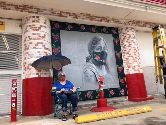 San Antonio based artist Kim Bishop's mother sits next to her daughter's mural outside of Jefferson Bodega. - FACEBOOK / JEFFERSON BODEGA