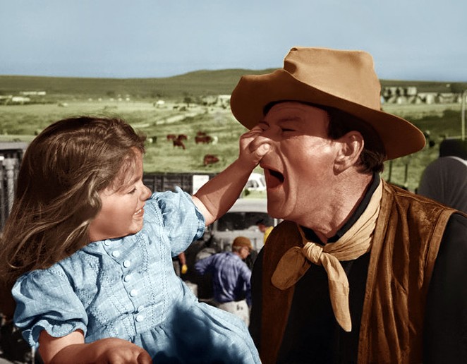 A young Aissa Wayne (left) photographed on set with her father. - Courtesy of Briscoe Western Art Museum