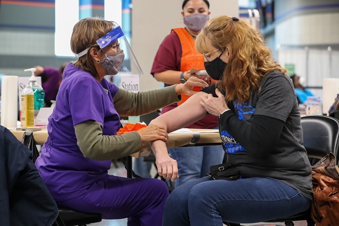 A woman receives her COVID-19 vaccination at the Alamodome. - COURTESY IMAGE / CITY OF SAN ANTONIO