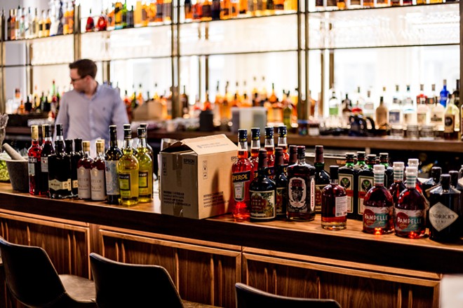 A bartender readies his bar for service. - Pexels / Sander Dalhuisen