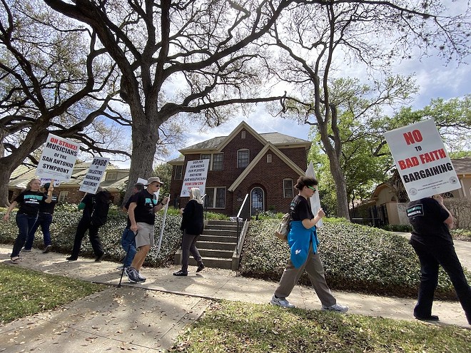 San Antonio Symphony musicians carry picket signs in front of the home of Symphony Society Chair Kathleen Weir Vale. - SANFORD NOWLIN