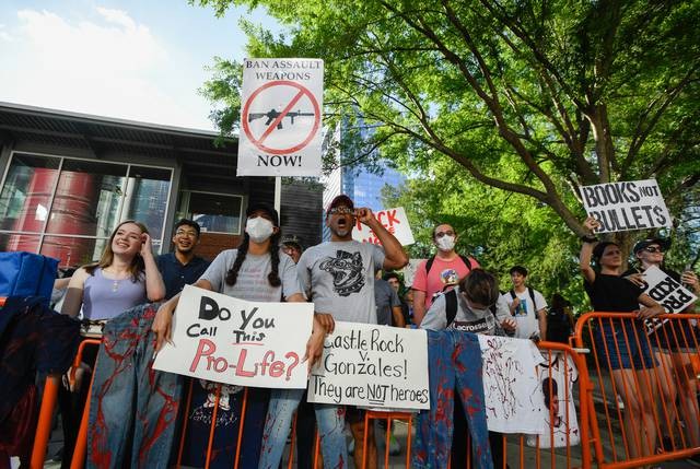 Protesters shout at attendees of the NRA Annual Meeting along in Houston on Friday. - Texs Tribune / Justin Rex