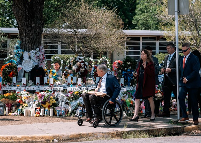 Gov. Greg Abbott approaches the memorial in front of Robb Elementary School as the gathered crowd boos. - Joseph Guillen