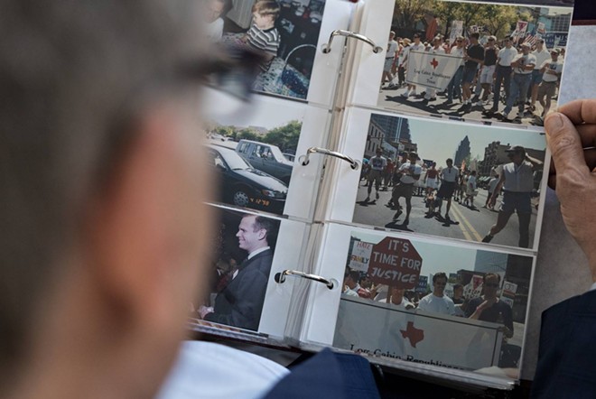 Dale Carpenter looks through photos from the 1998 Hate Crimes March in Austin. - Texas Tribune / Shelby Tauber