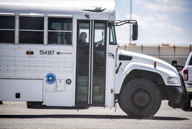 A bus from the Texas Department of Criminal Justice leaves an area near the International Bridge in Eagle Pass. - Texas Tribune / Sergio Flores
