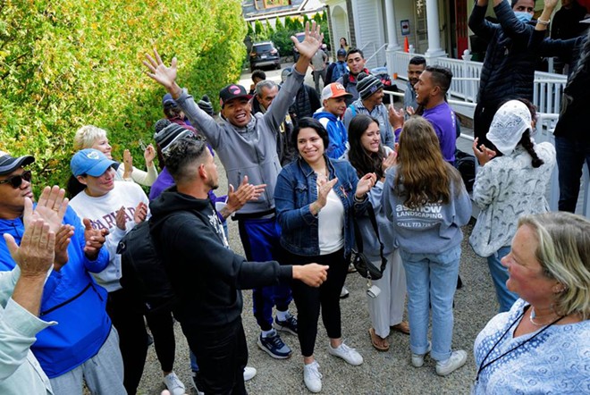 Venezuelan migrants and volunteers celebrate together outside of St. Andrew's Parish House in Martha’s Vineyard on Friday. - Boston Globe / Carlin Stiehl