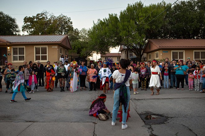 Attendees watch as a Día de los Muertos procession continues through the Alazán-Apache Courts in San Antonio on Nov. 1, 2022. - Texas Tribune / Azul Sordo
