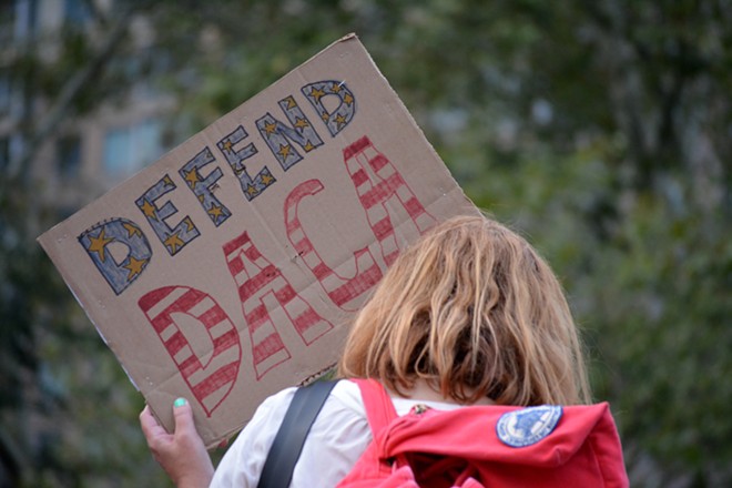 A protester holds a sign showing support for Deferred Action for Childhood Arrivals. - Shutterstock