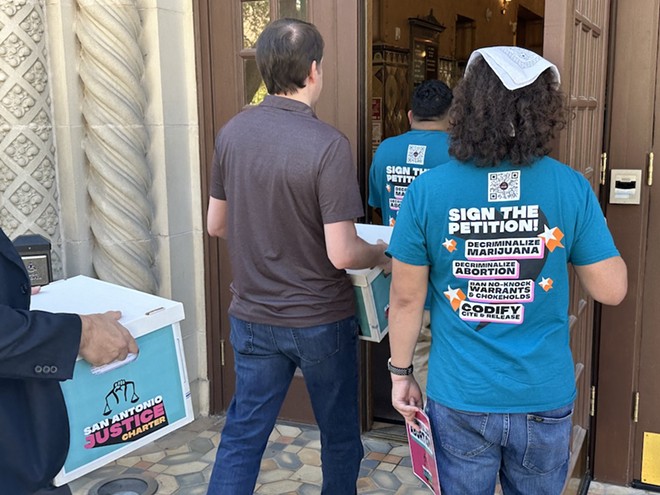 Supporters carry boxes of signed petitions in favor of the Justice Initiative into San Antonio City Hall. - Michael Karlis