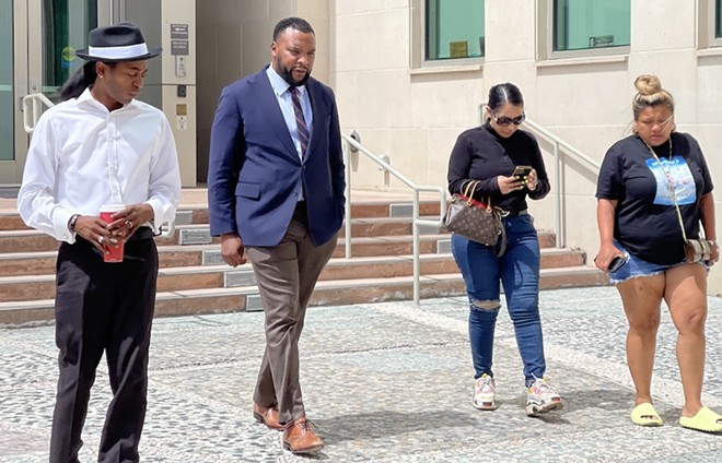 Civil rights attorney Lee Merritt (second from left) prepares to deliver a press statement during a visit to San Antonio last summer. - Michael Karlis
