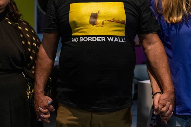 An attendee at the No Border Wall Coalition’s town hall in El Cenizo wears a “No Border Wall” T-shirt. - Texas Tribune / Michael Gonzalez