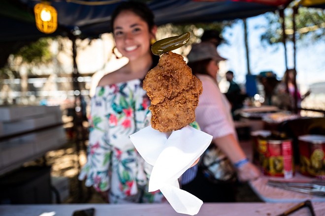 A vendor serves chicken on a stick at Oyster Bake. - Jaime Monzon