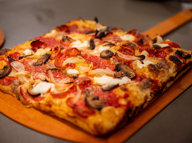 The Kick-Axe Supreme pizza sits on a pizza tray. - Courtesy Photo / GoodFood Branding & Marketing