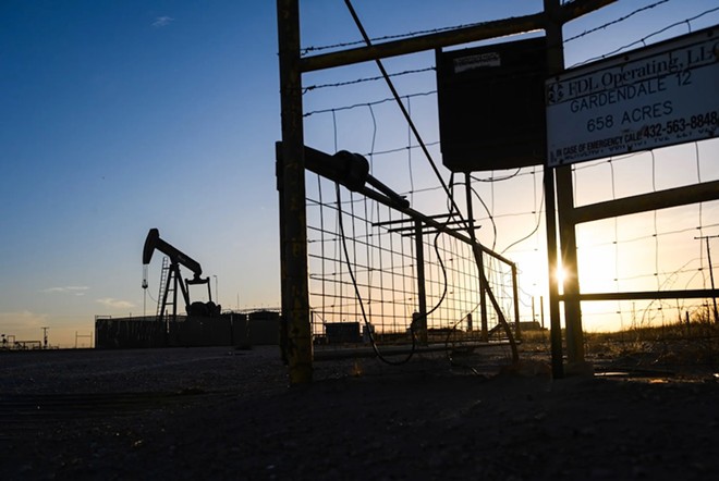 The sun begins to set behind a pump site in Gardendale on Sunday, Feb. 6, 2022. - Texas Tribune / Eli Hartman