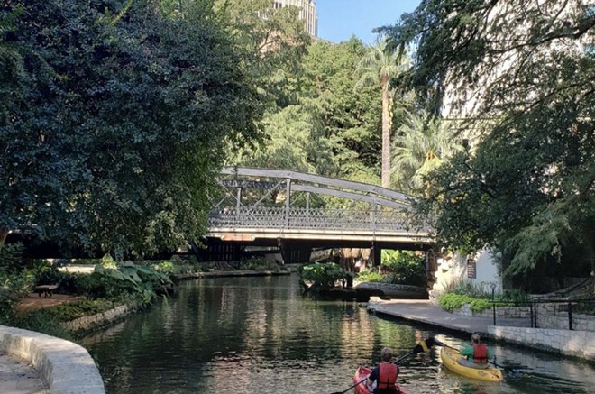 Kayakers boat beneath a downtown bridge. - Instagram / missionadventuretours