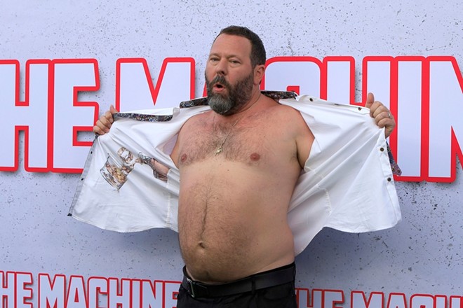 Bert Kreischer shows his chest at the premiere of his movie The Machine at the Village Theater in Westwood, Calif. - Shutterstock / Kathy Hutchins