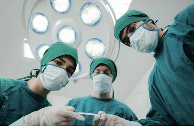 Medical professionals undertake a surgery. - Unsplash+