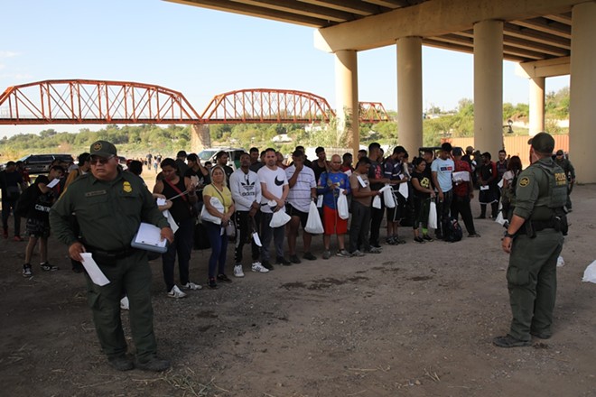 Border Patrol agents take a group of migrants seeking U.S. asylum into custody under the International Bridge in Eagle Pass last fall. Courts have long ruled that immigration enforcement is a federal responsibility, but Texas is contesting that with a controversial new state law that's being disputed in federal court. - Shutterstock / Vic Hinterlang