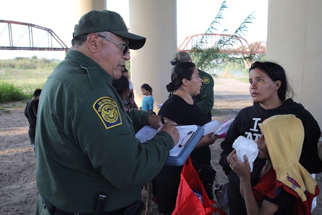 U.S. Border Patrol agents talk to asylum seekers who crossed into South Texas near Eagle Pass. - Shutterstock / Vic Hinterlang