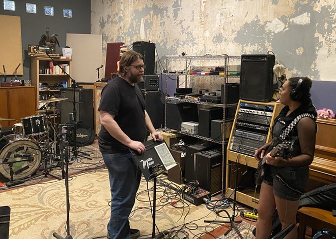 Studio E owner Brant Sankey (left) talks to Anelisa Huff, bassist for Daphne Kills Fred during a recording session. - Sanford Nowlin